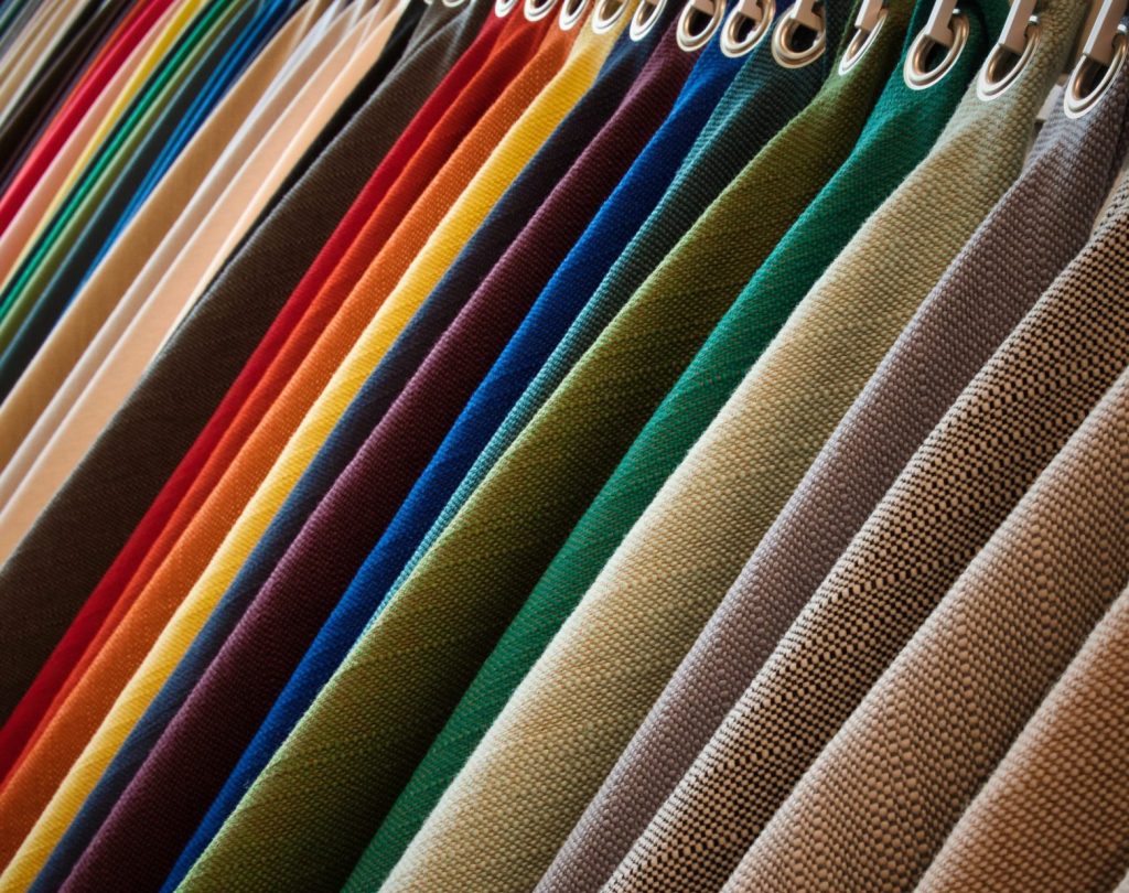 Line of hanging textured fabrics of different colors and shades A line of hanging textured fabrics of different colors and shades